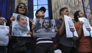 Protesters hold pictures during a protest in support of imprisoned activists who are in a hunger strike at prison, in front of the Press Syndicate, in Cairo