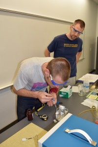 Ace Manning (SEU undergraduate) prepares an ozonesonde for flight while Physics Professor Paul Walter supervises.