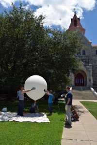 Filling the balloon with historic Main Building of St. Edward's University in the background.